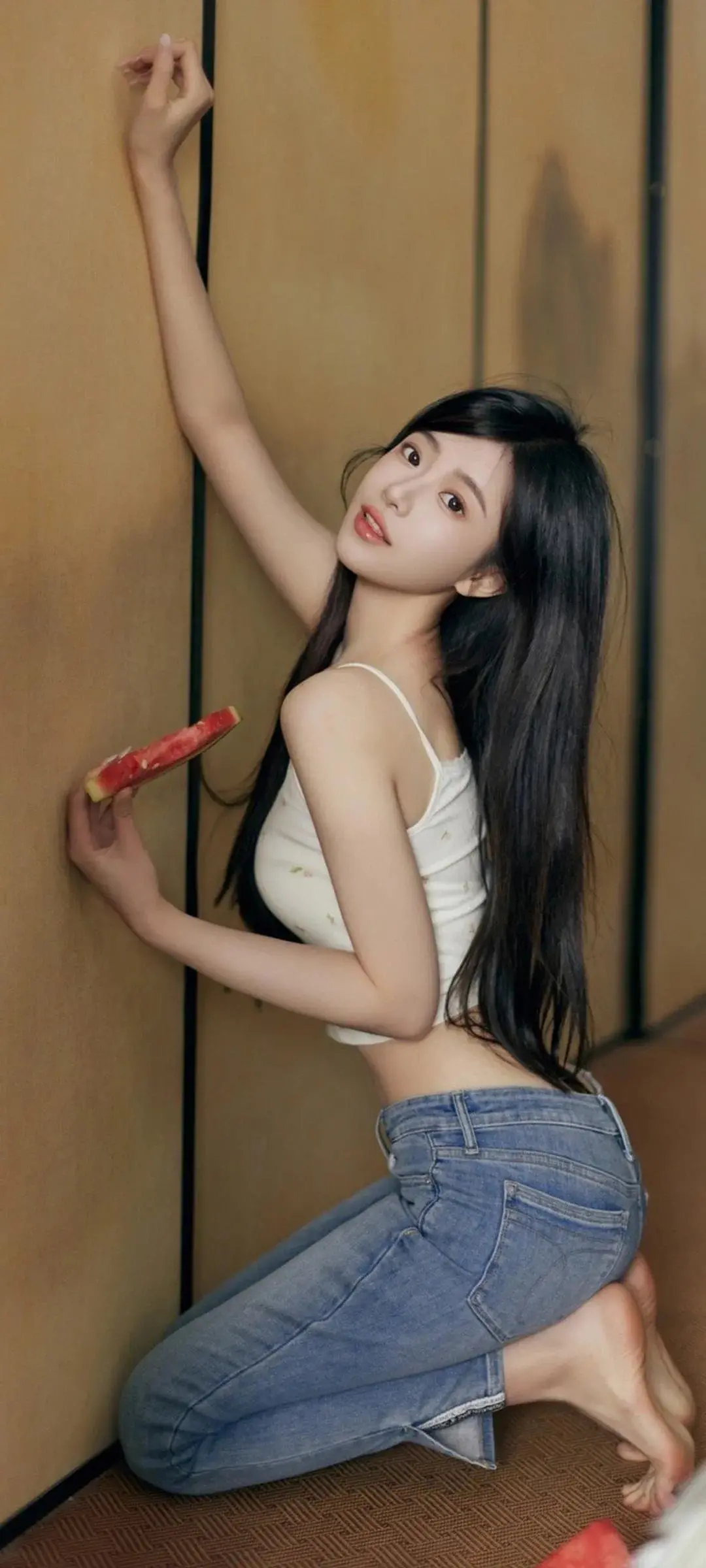 手拿西瓜跪坐摆拍牛仔裤少女