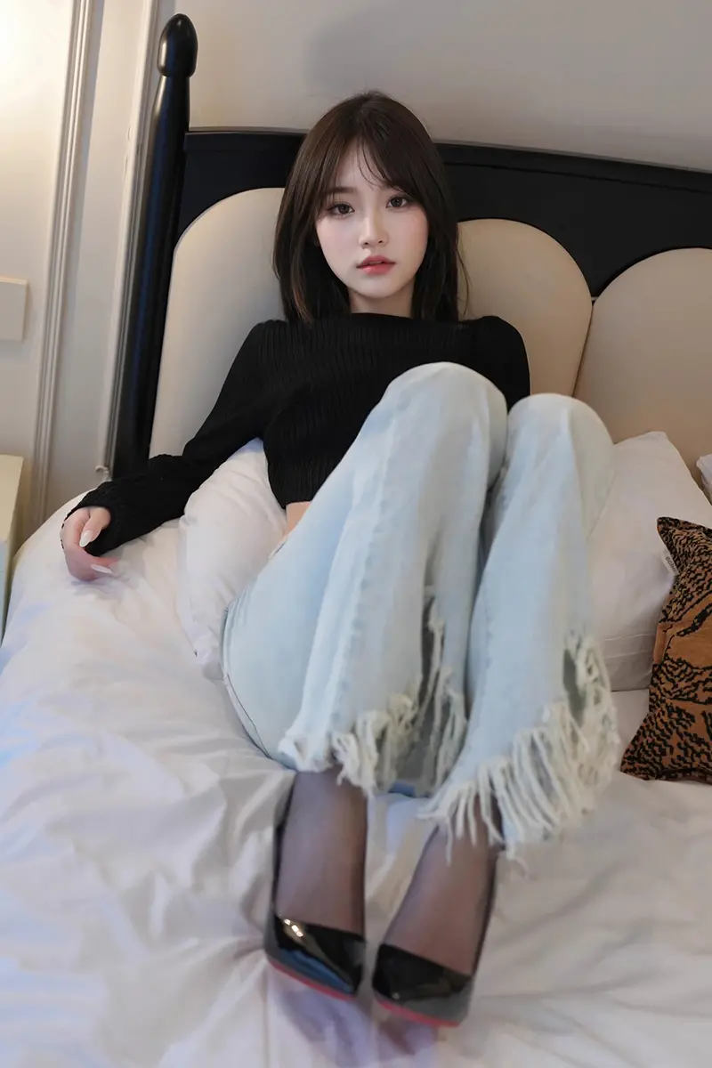 坐靠床头牛仔美女
